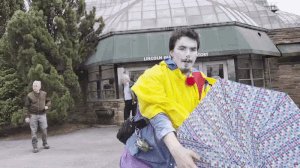 a clown struggles with his umbrella in the wind. When he finally gets it under control and poses, it inverts from the wind again